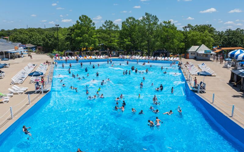 Crowd of guests playing in the Breaker Beach wave pool with rolling waves